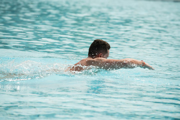 Swimmer young man sportsman swimming in pool with blue wate