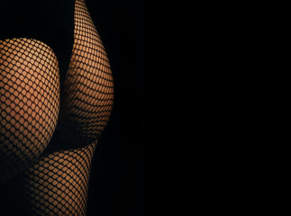 Hips and buttocks wearing black panties and fishnet pantyhose