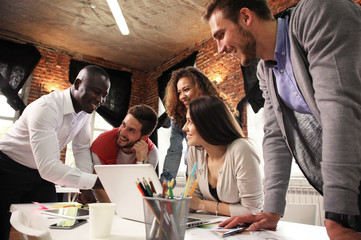 Teamwork concept.Young creative coworkers working with new startup project in modern office.Group of people analyze data on desktop computer