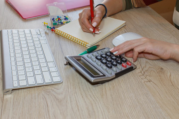 Woman working in office, sitting at desk, using computer. Business executive woman at workplace. Businesswoman Calculating Tax At Desk In Office