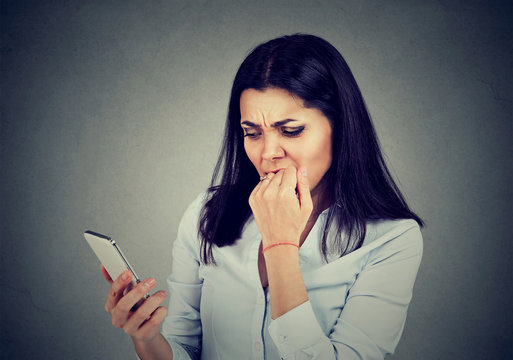 angry anxious woman watching apps in the mobile phone