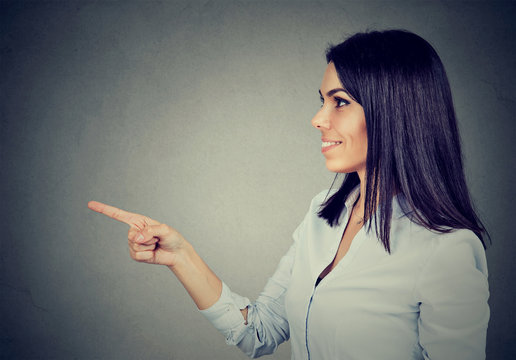 Happy woman pointing with finger at blank copy space