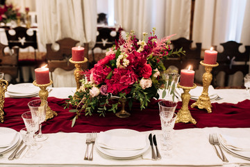 Candles with decor and flowers, burgundy and red color