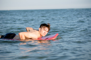 Teenage boy with a body board in the sea