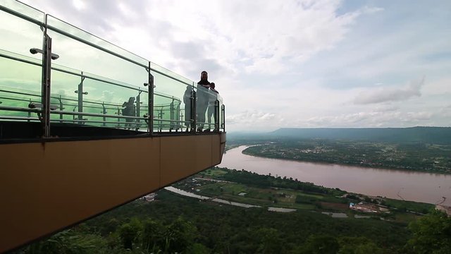 NONGKHAI,THAILAND-JULY 1,2017: Thais peple tourists walking on cliffside glass skywalk are watching beautiful Mekong River at Wat Pha Tak Suea in Amphur Sungkhom,Nong Khai Province, Thailand.