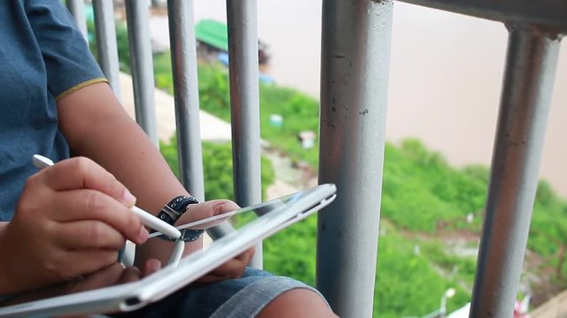 businesswoman relaxing and use tablet computer at terrace near river border beautiful tropical
