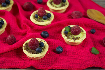 A delicious dessert with vanilla pudding in a basket with fresh raspberries and blueberries. Light summer sweets