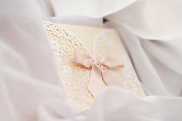 white wedding card, wedding invitation, gift on neutral white a curtain a background