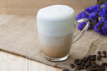 A cup of hot cappuccino coffee on wood table.