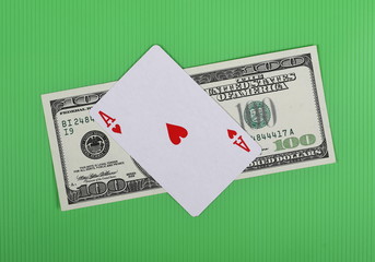 Hundred dollar bill and ace card on green background and texture