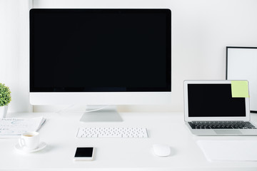 Bright designer desktop with pc and laptop