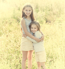 Fototapeta premium sibling sisters hugging each in the field