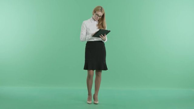 a smart girl stands holding a tablet in hands