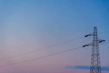 Powerline against sunset sky.