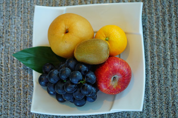 Mixed whole fruit on a white platter