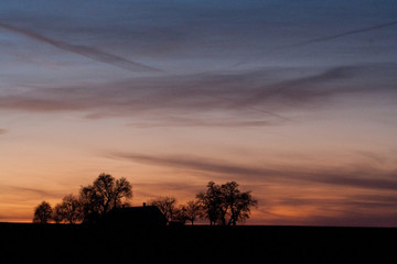 Fototapeta na wymiar Sonnenuntergang hinter einsamen Haus