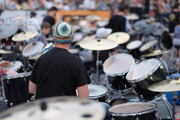 A participant in a concert of percussion music behind a drum set