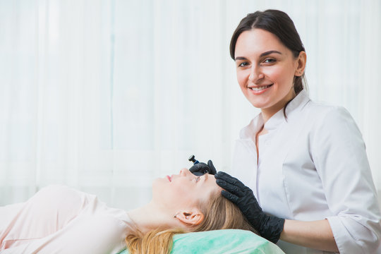 Beautician cosmetologist applying permanent makeup
