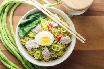 Instant vegetable noodles in a bowl on wooden background.