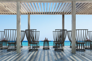 Dark wooden chairs and tables, seaside