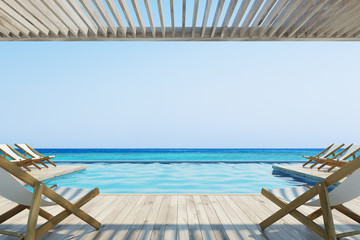Pier with white deck chairs near a pool