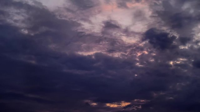 Dark clouds with sunset behind. Dawn hell timelapse cloudes with demonic mood. Sunset moving colors from orange to gray.