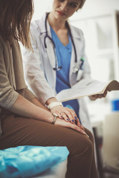 Doctor and patient discussing something while sitting at the table . Medicine and health care concept. Doctor and patient