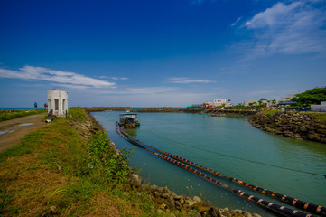 Obraz premium MANABI, ECUADOR - JUNE 4, 2012: Stagnant water with a water pumping machine at Same, Ecuador in a beautiful blue sky in a sunny day