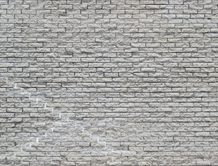 white brick wall background with cracks and repairs repeating pattern