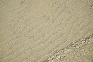 beach water surface with ripple and sand background