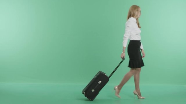 a nice woman is walking with a suitcase