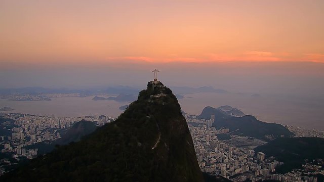 Aerial wide angle view of Christ and Sugarloaf Mountain at dusk with warm sky color, Rio de Janeiro, Brazil