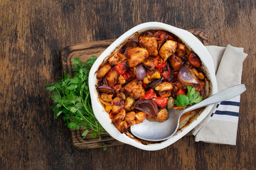Baked chicken breast with vegetables on dark rustic wooden table