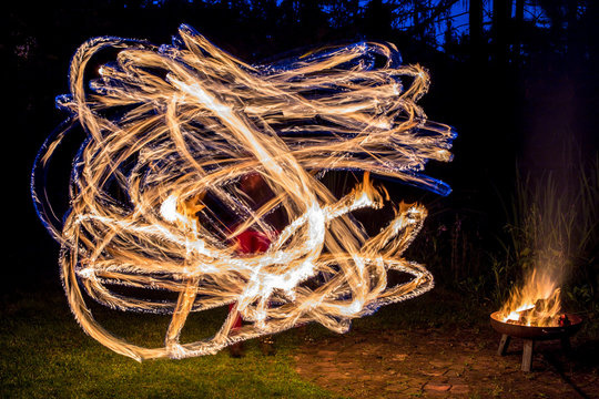 ein K&uuml;nstler arbeitet mit brennenden Pois