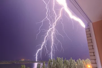 Photo sur Aluminium brossé Orage Lightning strikes the roof of the house