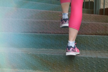 Fototapeta na wymiar Woman athlete climbing stairs
