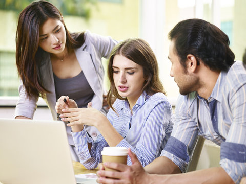 Asian And Caucasian Business People Working Together In Office