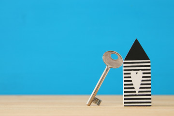 small house model with key over wooden floor. selective focus