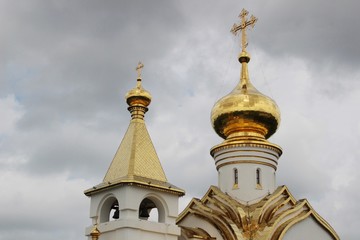 Fototapeta na wymiar Church, temple, religion, russia, christianity, golden, cathedral, cross, golden domes, pillars, chain, sky, gray, white