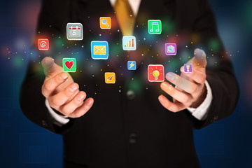 Businessman holding application icons