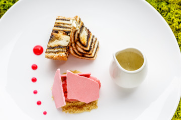 Several different desserts (ice cream, pies and meringues) lie on a white plate