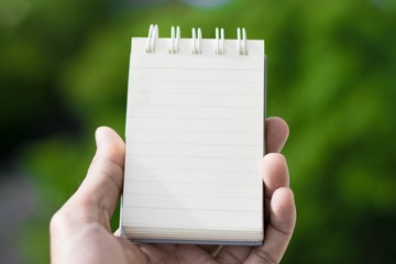 white paper or book and man holding on the tree bokeh background using wallpaper and background for  note work.