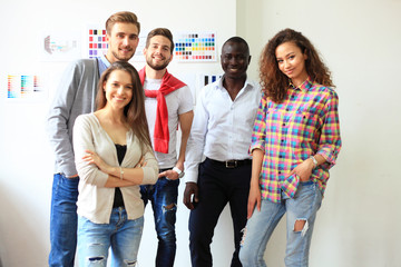 Portrait of happy young people in a meeting looking at camera and smiling. Young designers working together on a creative project