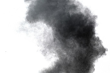 Black powder explosion. Closeup of black dust particles explode isolated on white background.