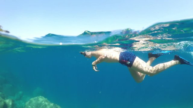 swimmer in flippers dives into the sea, raw, 4K