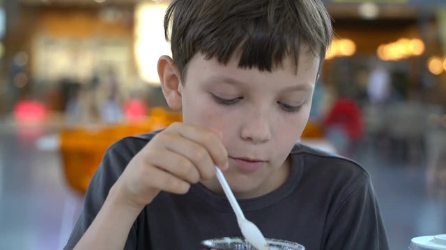 boy eating brownie with ice cream in a cafe.