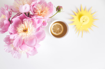 Bouquet of peonies, tea with lemon, notebook , photo in gentle colors. Good morning. Have a nice day! Place for text
