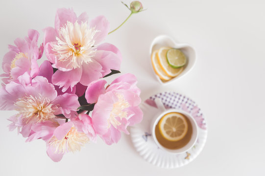 Bouquet of peonies, tea with lemon, photo in gentle colors. Good morning. Have a nice day! Place for text
