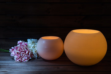 Velas redondas y hortensias sobre fondo de madera.
