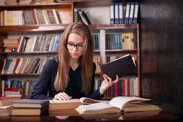 girl student sits in the library reading